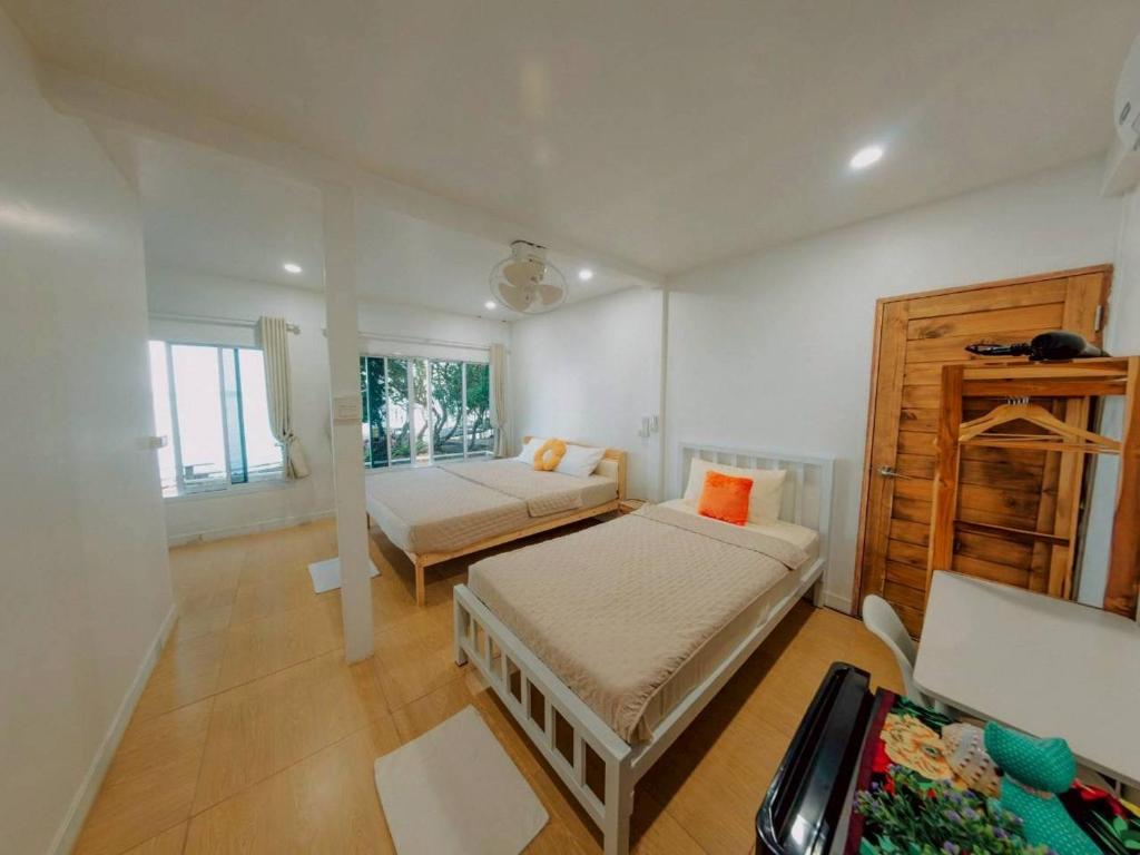 a bedroom with two beds and a table in it at Baankonhualamkohlibong in Ko Libong Island
