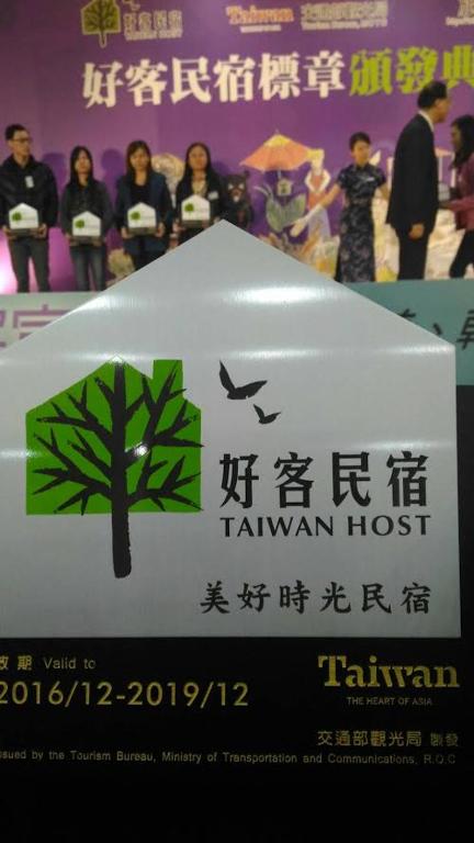 a sign with a tree and birds on it at Good Time B&amp;B in Jiufen