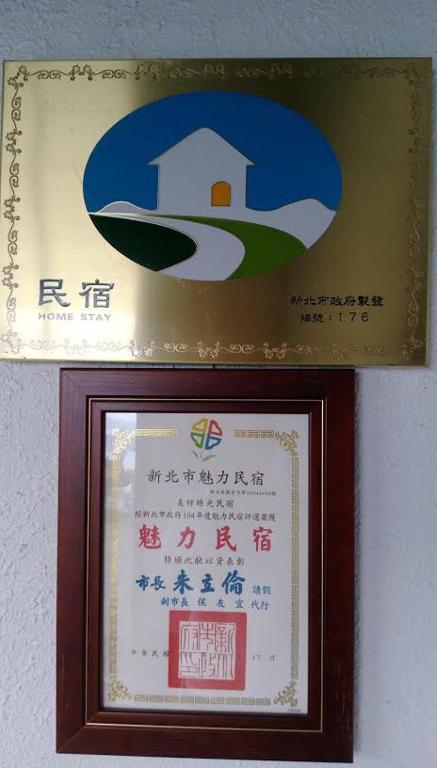 a framed sign with a picture of a house at Good Time B&amp;B in Jiufen