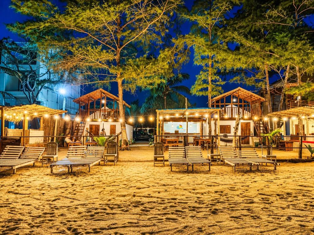 a beach with chairs and umbrellas at night at Arugam Bay Holiday in Arugam Bay
