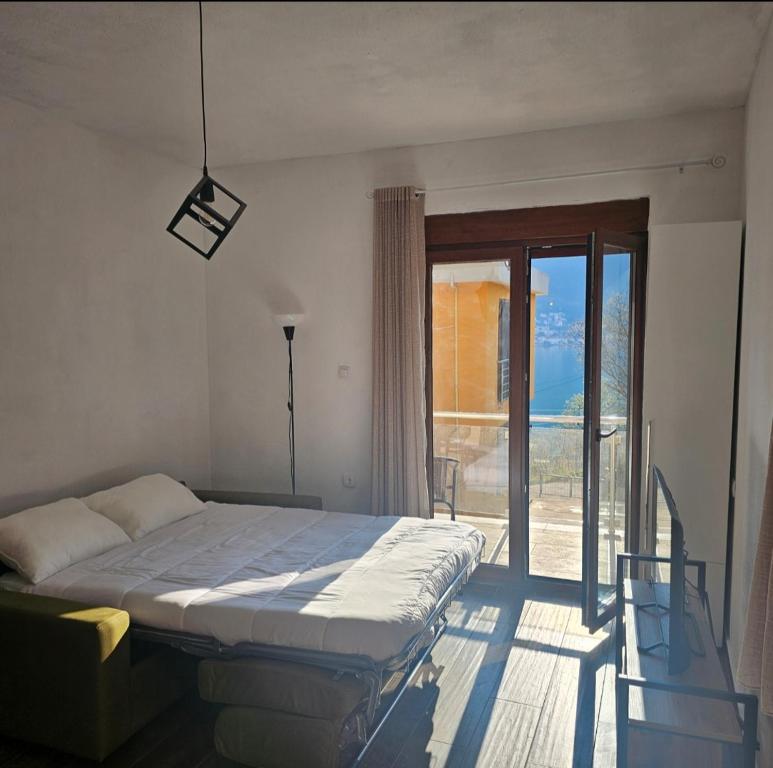 a bedroom with a bed and a sliding glass door at Apartments Agnes in Dobrota