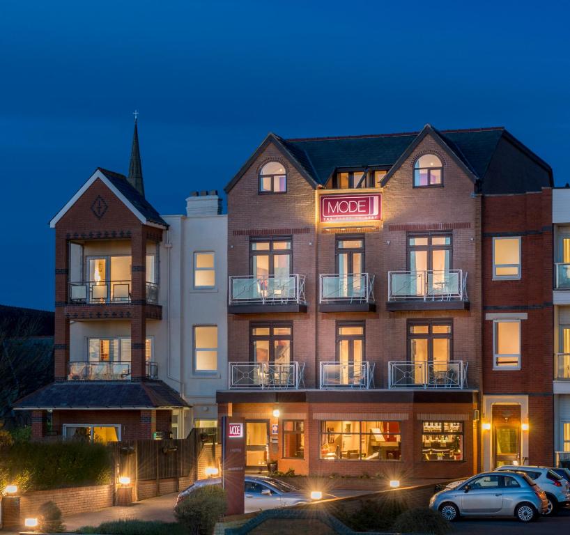 a hotel with cars parked in a parking lot at Mode Hotel St Annes in Lytham St Annes