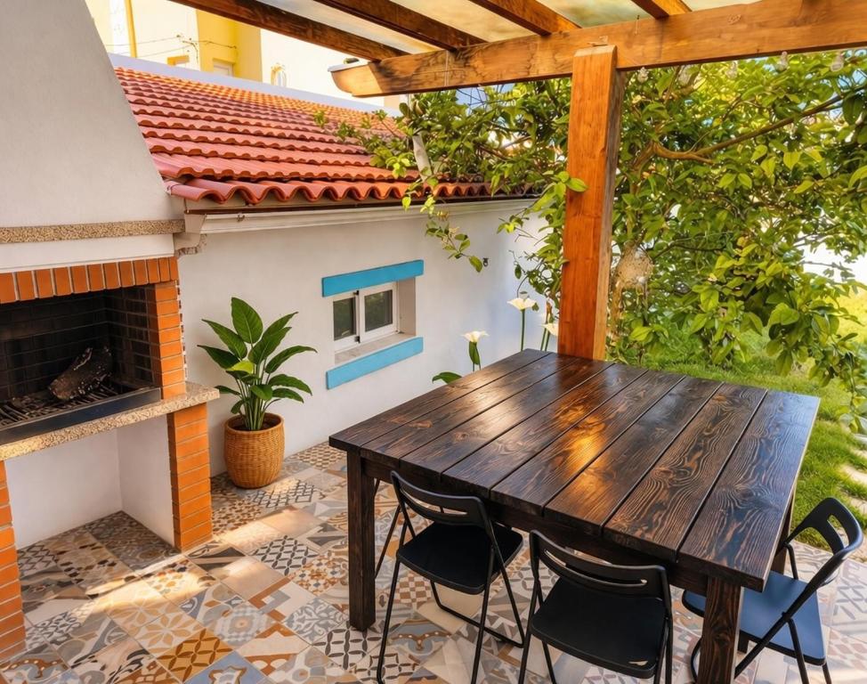 a wooden table and chairs on a patio with a fireplace at Akistay Guest House - Caparica in Costa da Caparica