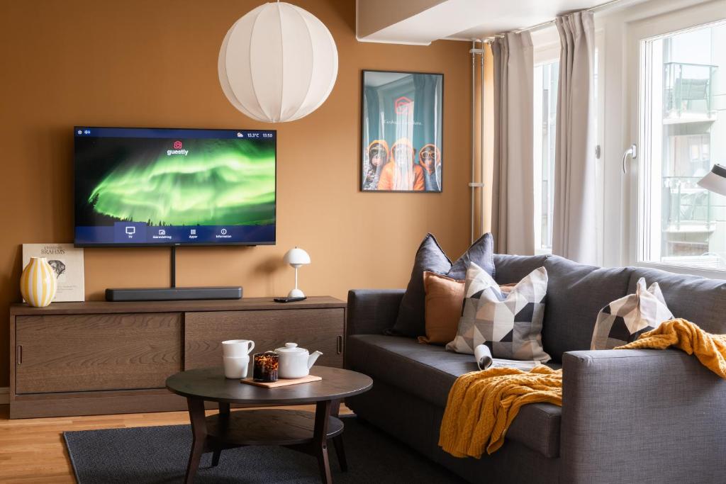 a living room with a couch and a flat screen tv at Guestly Homes - Central Premium Studio in Västerås