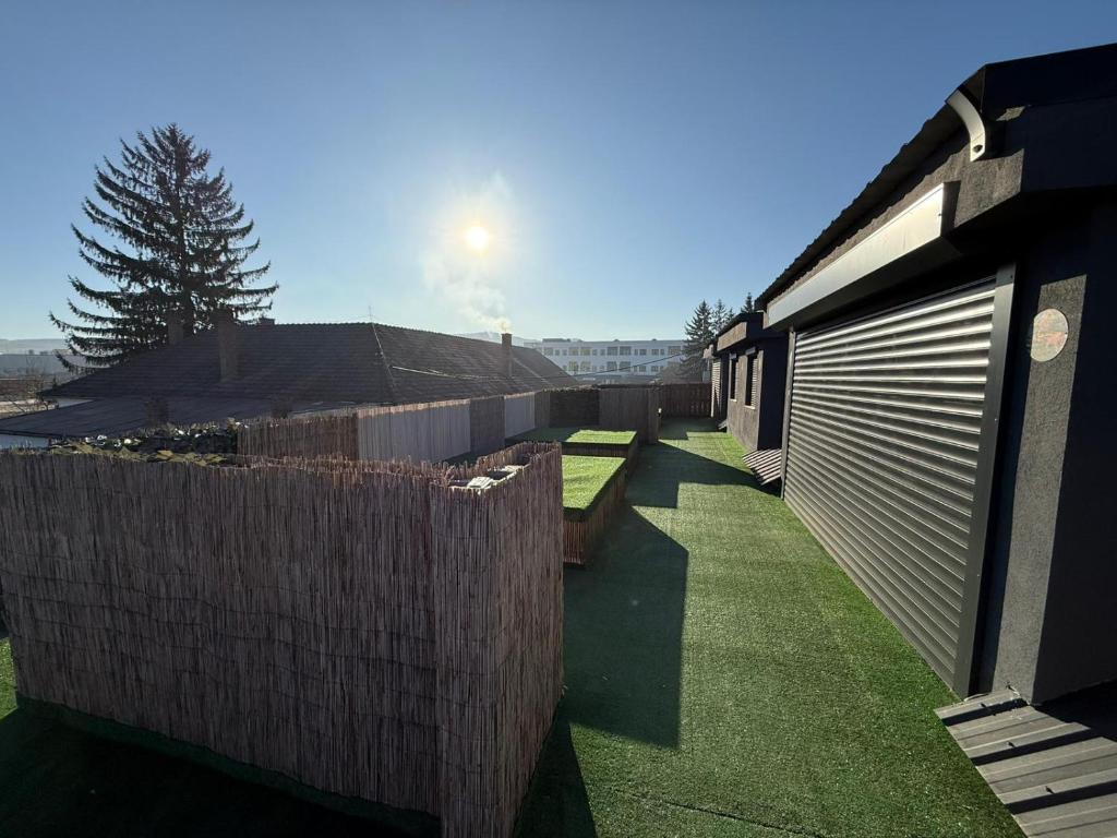 a backyard with a wooden fence and a building at Intimissima apartman in Odorheiu Secuiesc