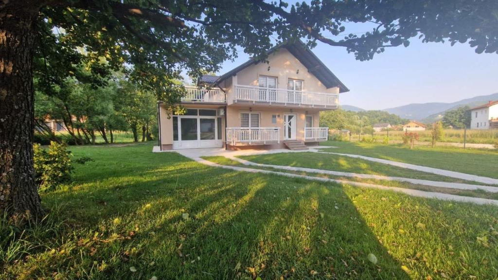 a house with a large yard with a tree at Villa Nature in Hadžići