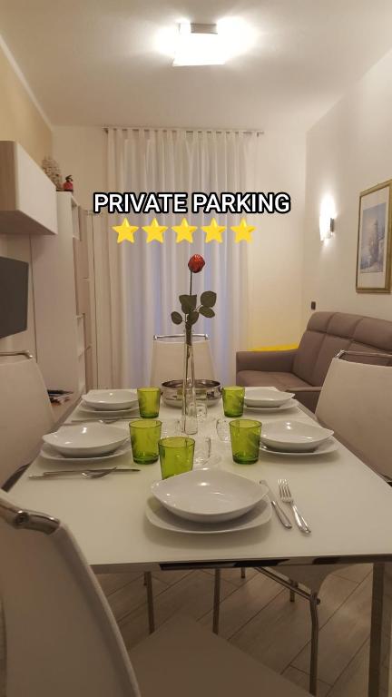 a white table with plates and a vase with a rose at Karina House - Como in Como