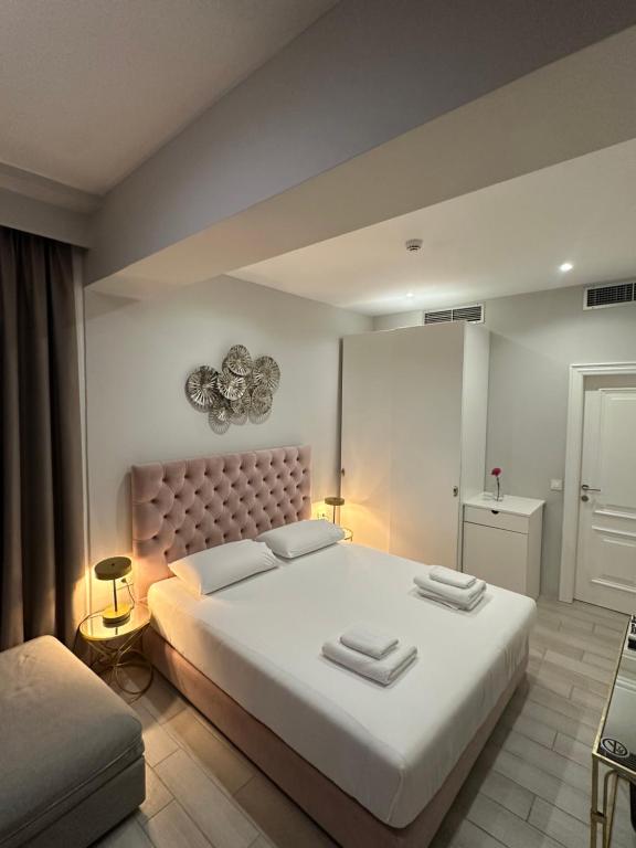 a bedroom with a large bed with two towels on it at Ajsel Luxury Rooms in Sarandë