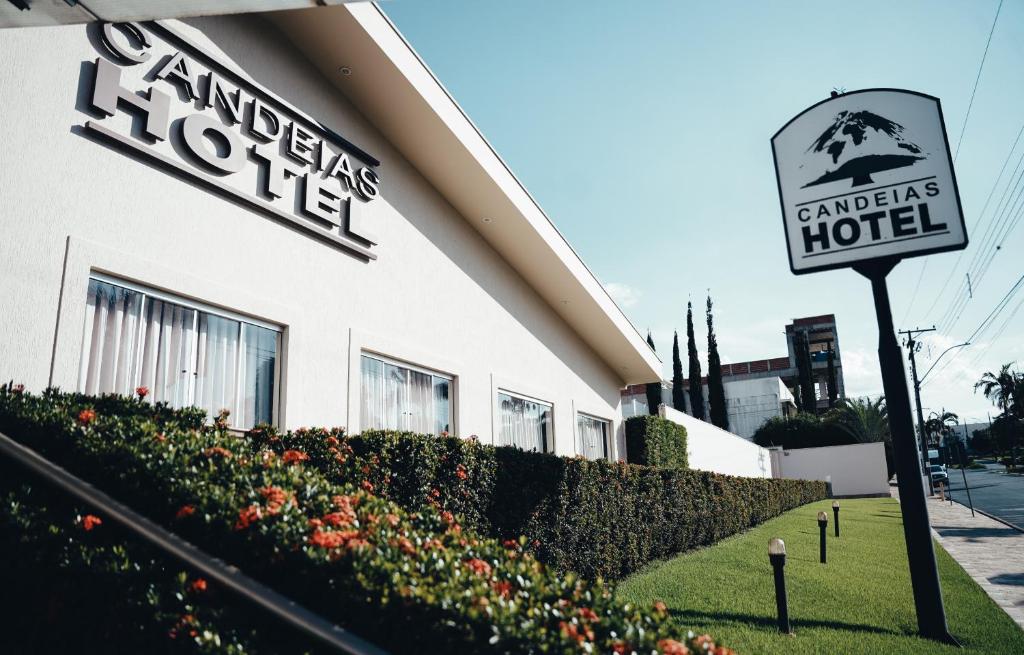 a hotel sign in front of a building at Candeias Hotel in Batatais