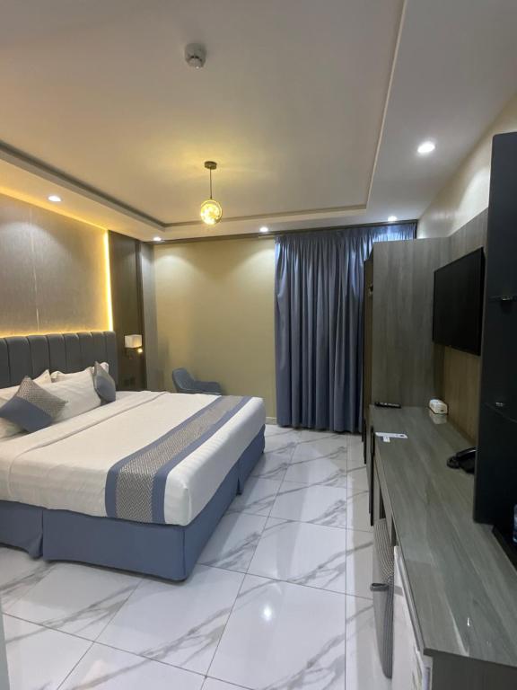 a bedroom with a bed and a flat screen tv at فندق اجنحه البيداء فرع2 AlBaydaa Suites Hotel Branch in Medina