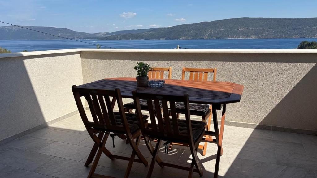 a table and chairs on a balcony with a view of the ocean at Villa Nika & Eva Valun in Cres