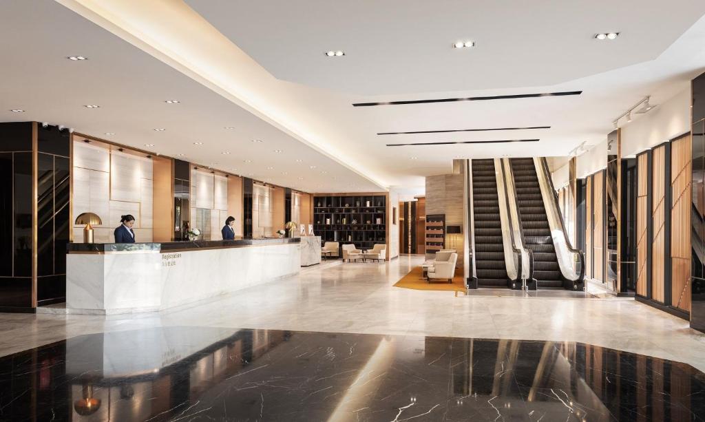 The open lobby with reception, lounge seating, bar shelving and escalators.