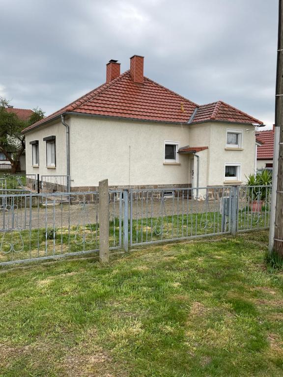 a white house with a fence in front of it at Ferienhaus Mila in Löbau
