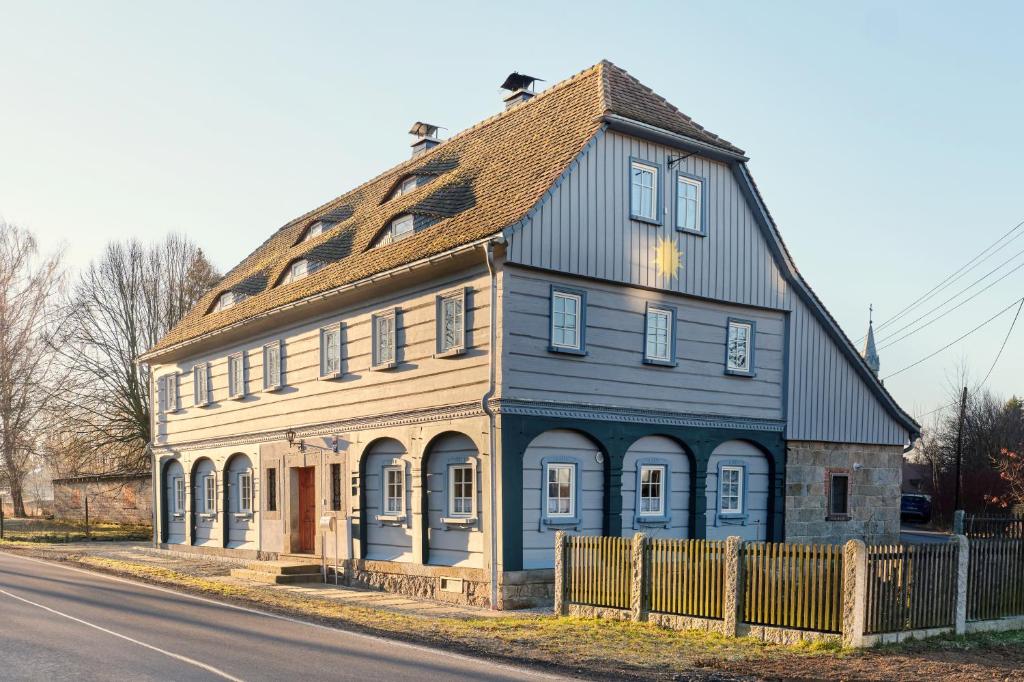an old house with a blue roof on the side of the road at Ferienhaus Sonne in Jiříkov