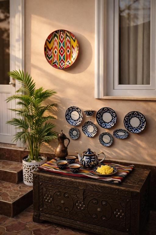 a table with plates and dishes on a wall at Sole Family Guesthouse in Samarkand