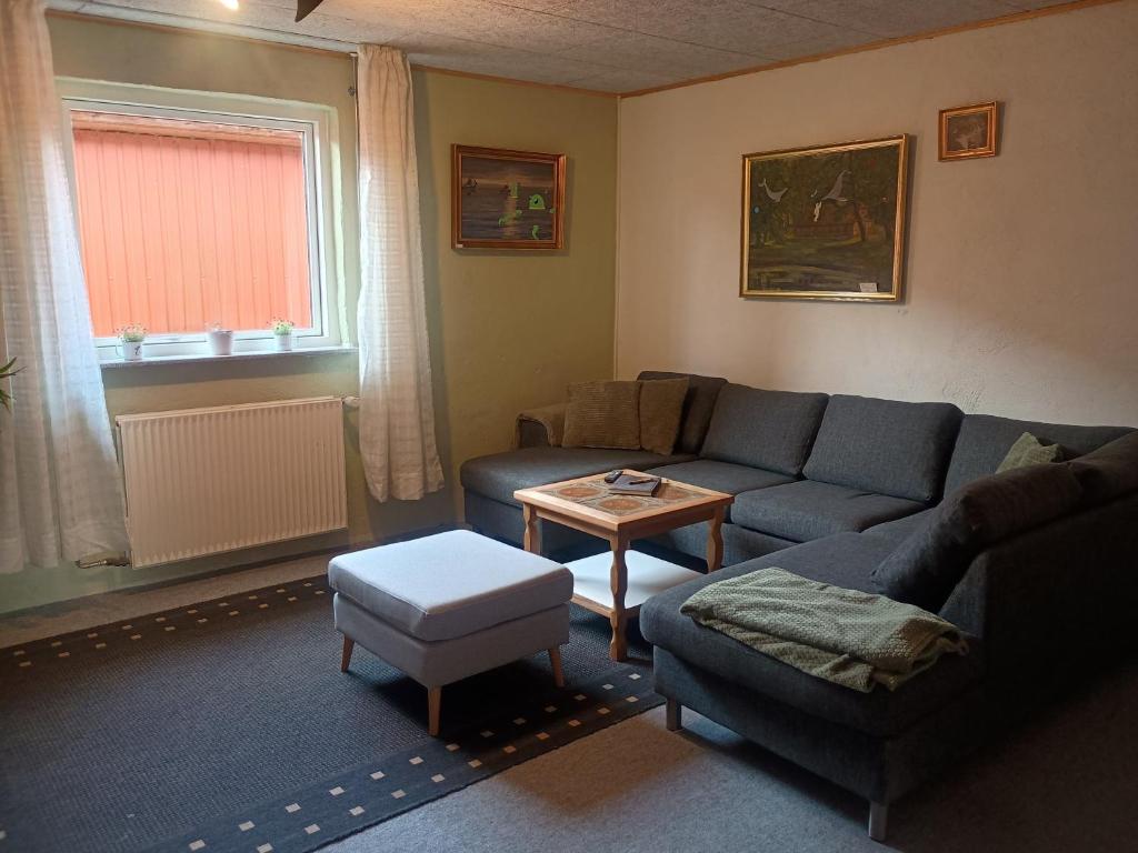 a living room with a couch and a table at 70 m2 Anneks på gården in Malling