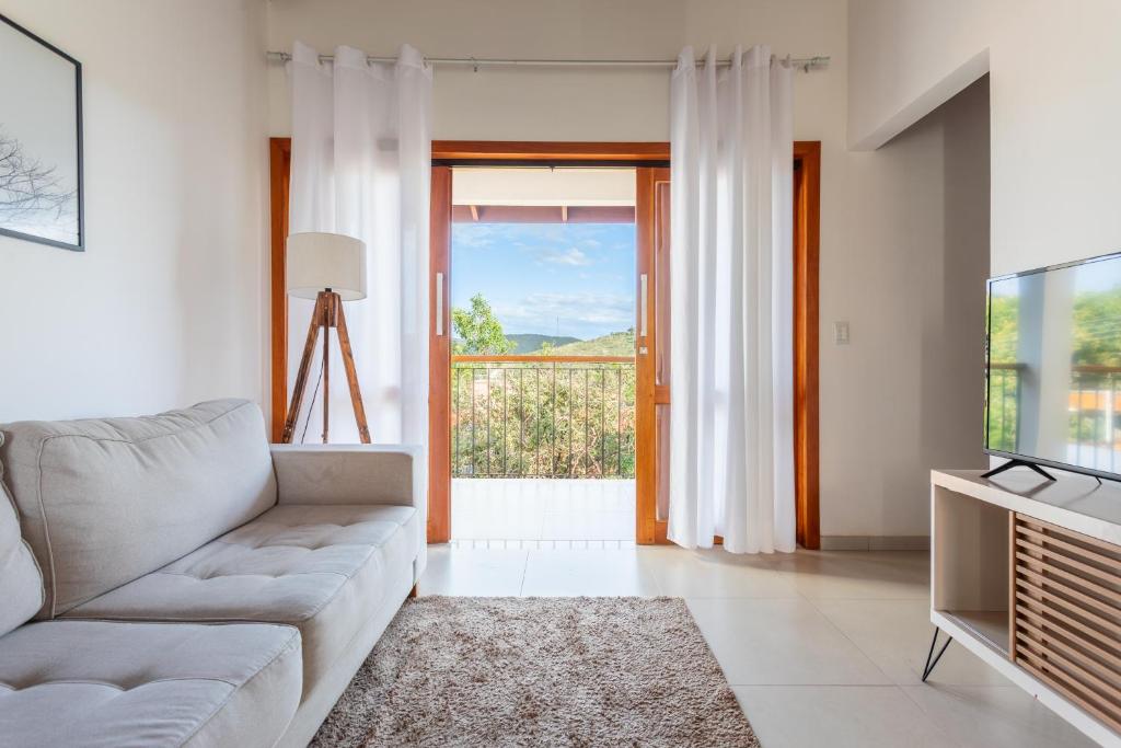 a living room with a couch and a television at Cerrado Ville in Alto Paraíso de Goiás