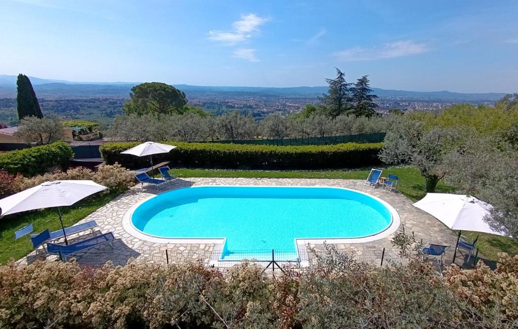 a swimming pool in a yard with umbrellas at Appartamento con piscina in Villa in Florence