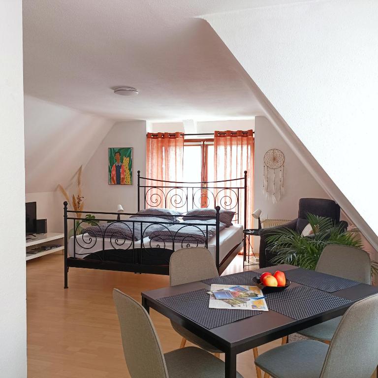 a bedroom with a bed and a table and chairs at Urban Apple in Bad Mergentheim