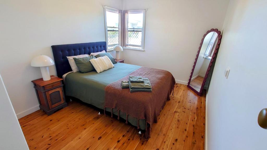 a bedroom with a bed and a wooden floor at Home in Newtown in Toowoomba