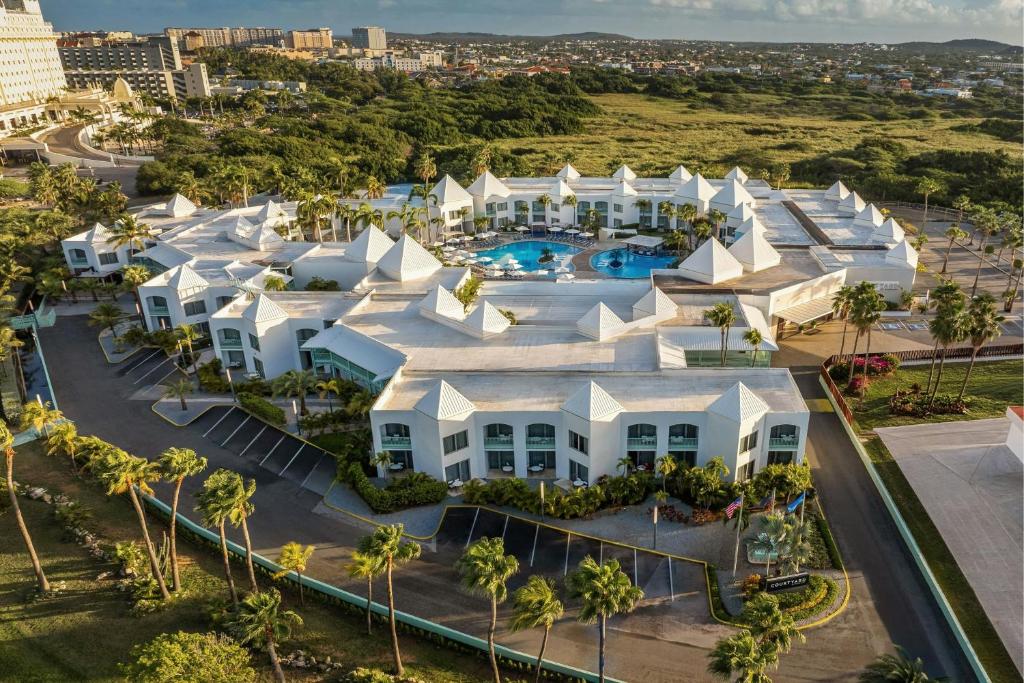 an aerial view of a large white building with a pool at Courtyard by Marriott Aruba Resort in Palm-Eagle Beach