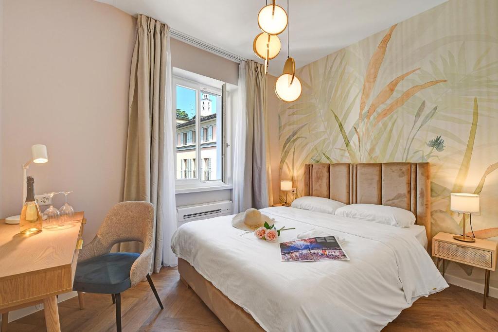 a bedroom with a bed and a desk and a window at Central Suites in Lugano
