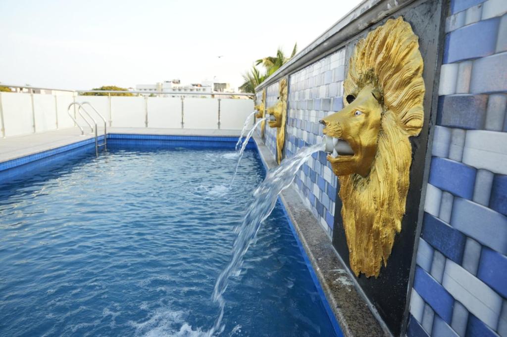 a fountain with a lion head on the side of a building at JPR Heritage Villa in Pondicherry