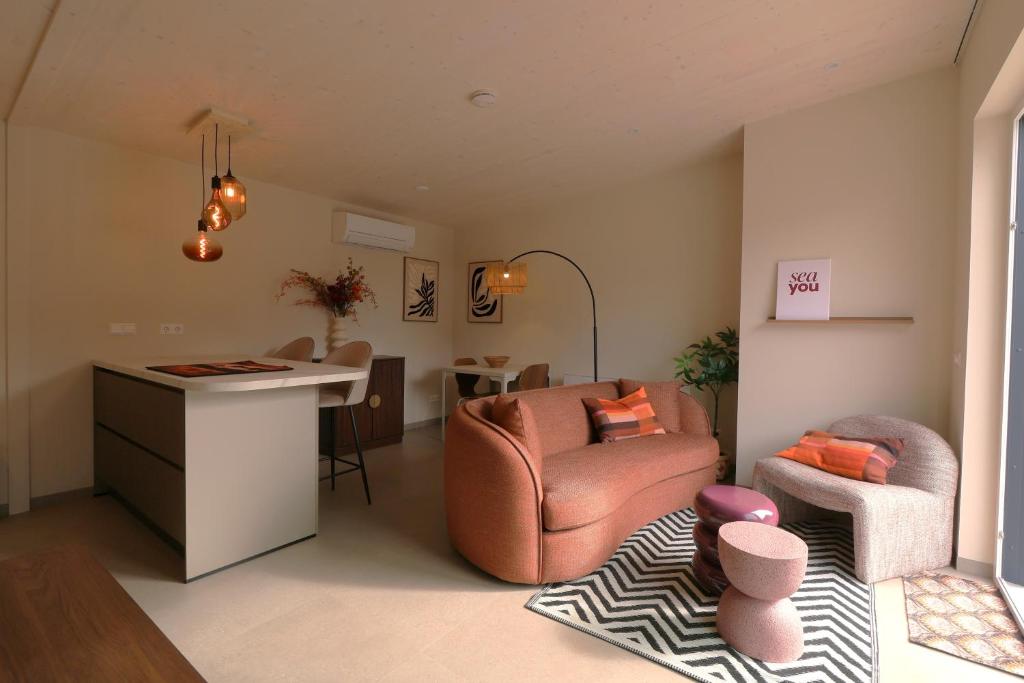 a living room with a couch and a chair and a desk at Vakantiewoning Koestraat 48A met strandcabine in Westkapelle
