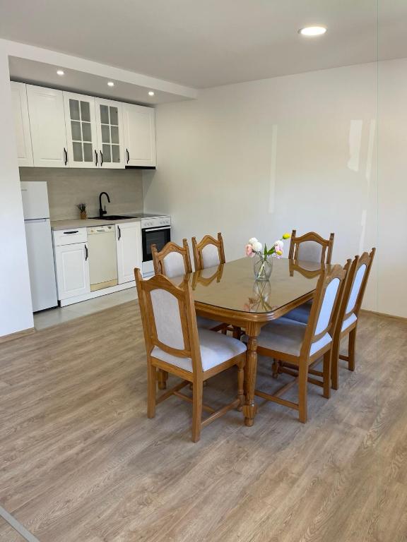 a kitchen and dining room with a table and chairs at Elbas Apartman in Široki Brijeg