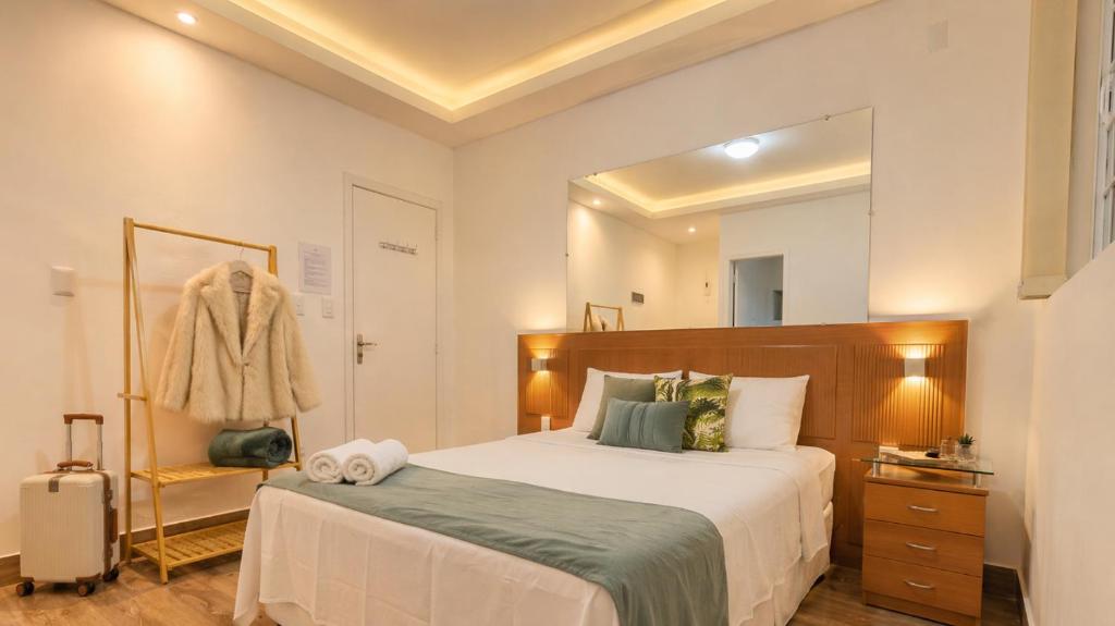 a bedroom with a bed and a large mirror at Casa da Marquês in Petrópolis