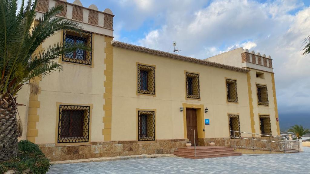 a building with a palm tree in front of it at Mirador de Aledo in Aledo