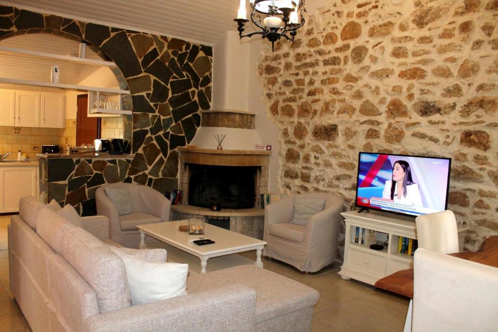 a living room with a couch and a tv at Spiti Mata in Perítheia
