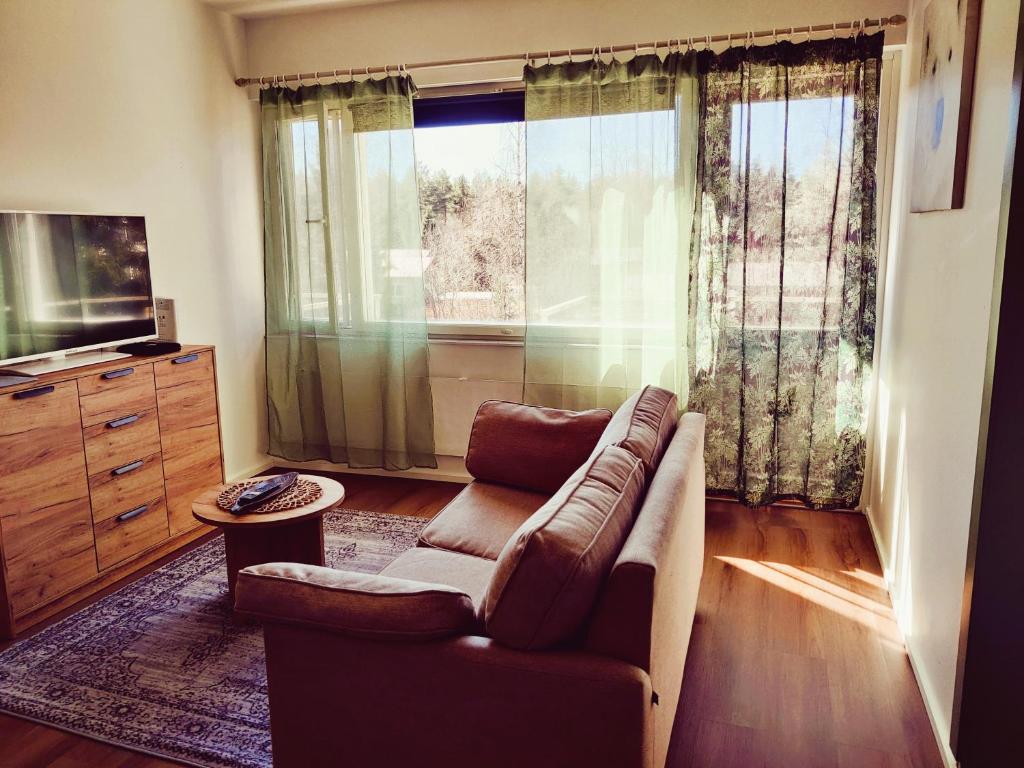 a living room with a couch and a large window at Yyterin Kontu in Pori