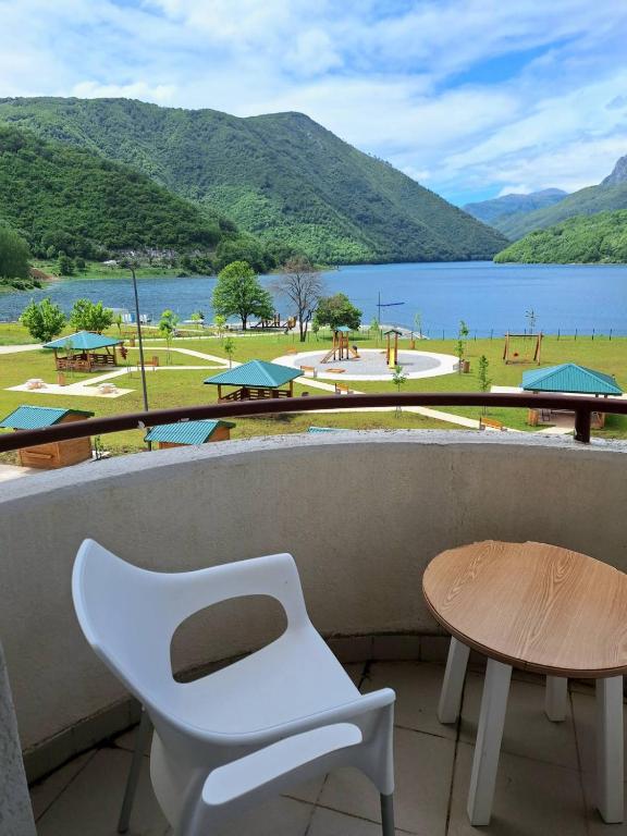 a white chair and a table and a view of a lake at Apartment Harmony in Plužine