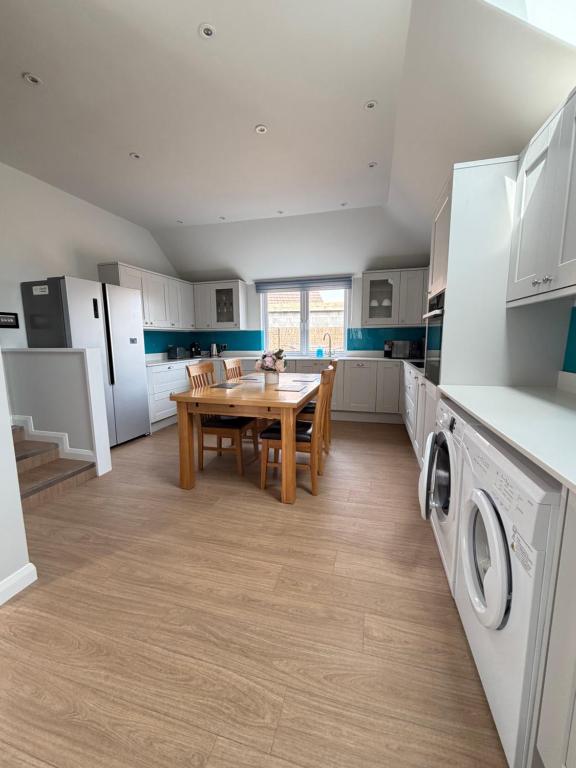 a kitchen with a wooden table and a dining room at Teran the apartment in Timsbury