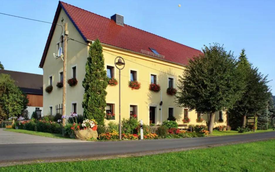 a large yellow building with a red roof at Landhaus Fröde in Kurort Rathen