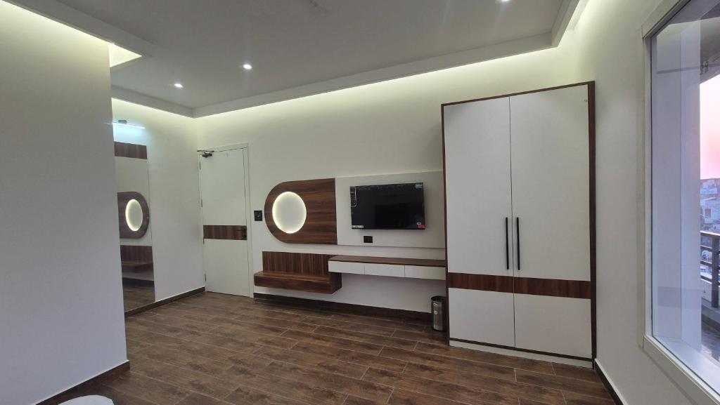 a living room with a tv and a large white cabinet at Shri banke bihari complex in Jalesar