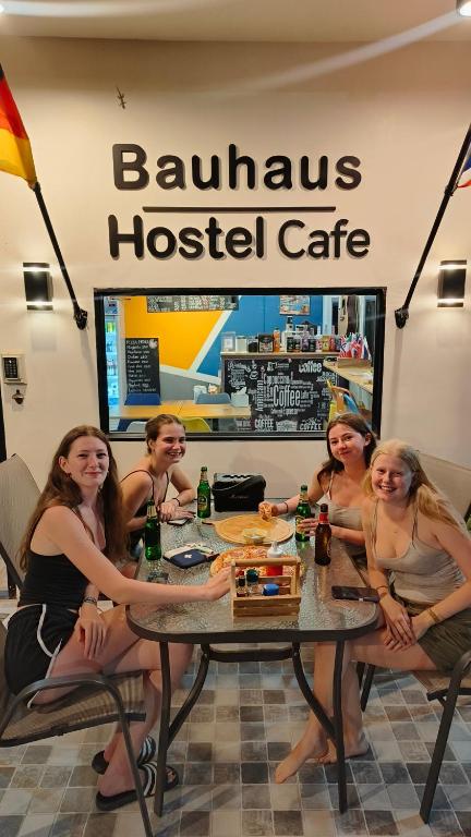 a group of people sitting at a table in a restaurant at Bauhaus Hostel Cafe in Don Sak
