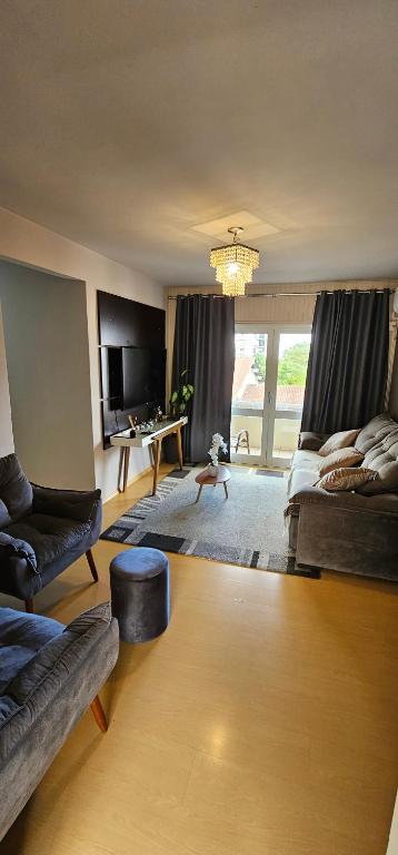 a large living room with a couch and a table at Apartamento amplo, confortável e central! in Veranópolis