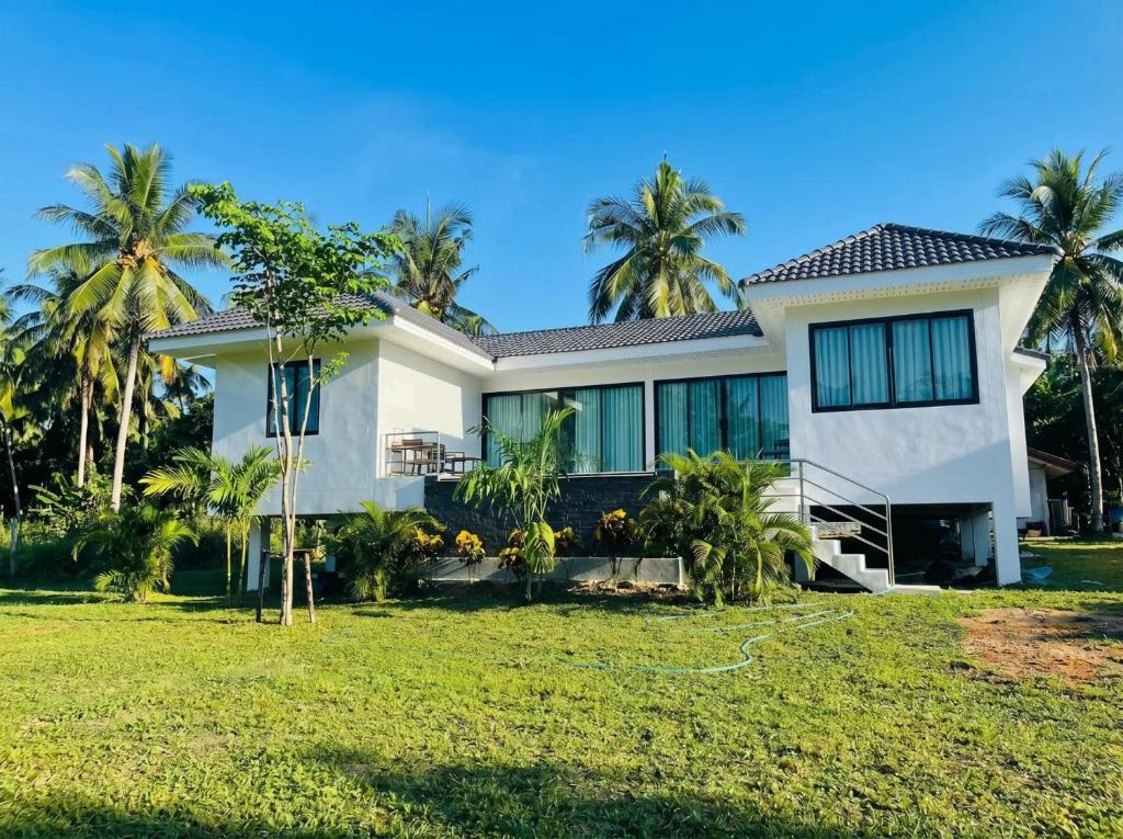 a house with palm trees in front of it at Nirvana Phangan Villas - Luxury & Serenity in Wok Tum