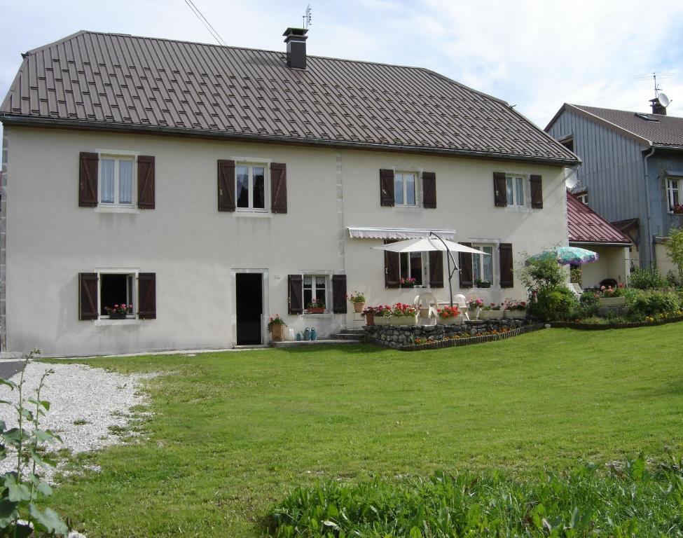 a large white house with a large yard at Gites familiaux à Lajoux à 1180m d'altitude in Lajoux