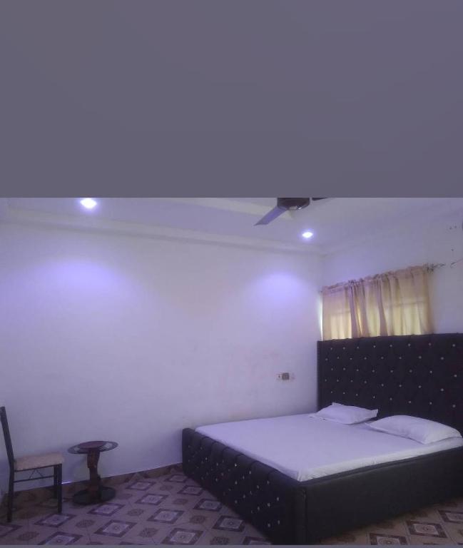 a bedroom with a bed and a blue light at Modern Way Guesthouse in Kasoa