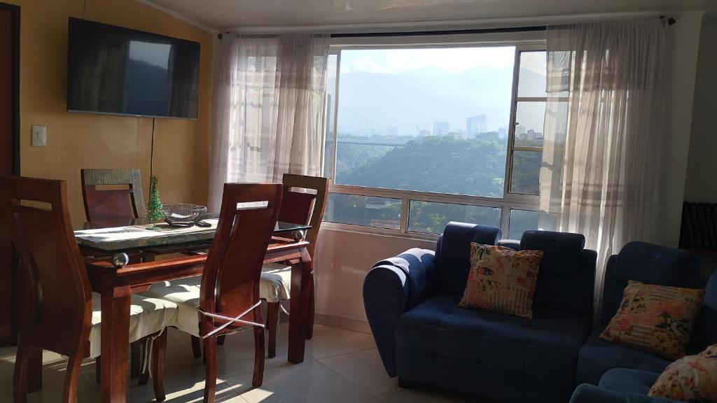 a living room with a table and chairs and a window at Apartamento con vista a la ciudad en barrio campo hermoso 301 in Bucaramanga
