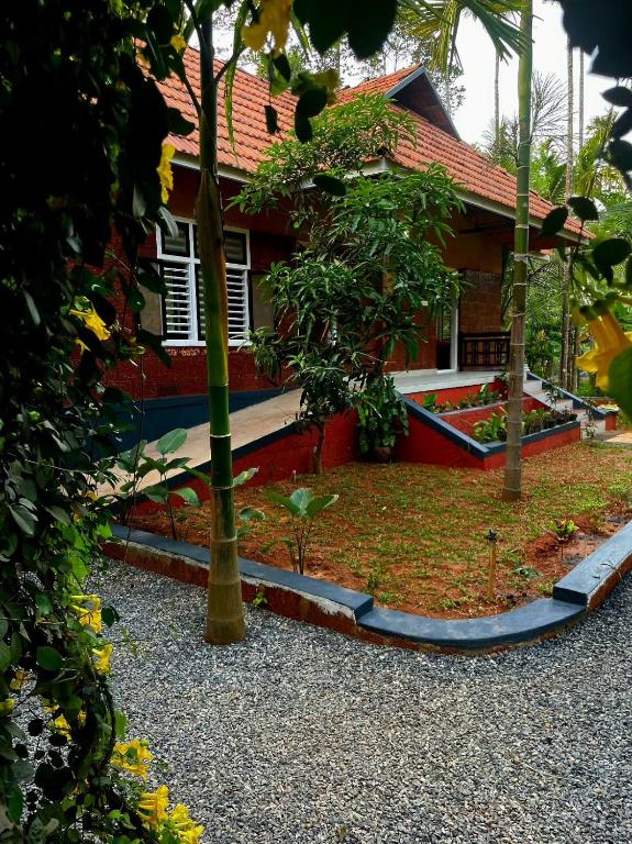 a house with a garden in front of it at Mitra retreats in Mānantoddy