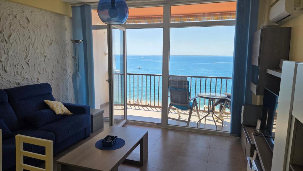 a living room with a couch and a view of the ocean at Primera Linea de playa in Almería