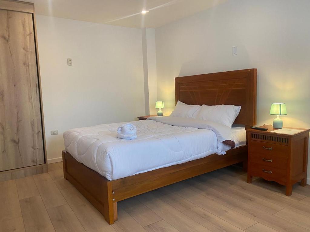 a bedroom with a large bed and two night stands at Condor Palace in Huayllay