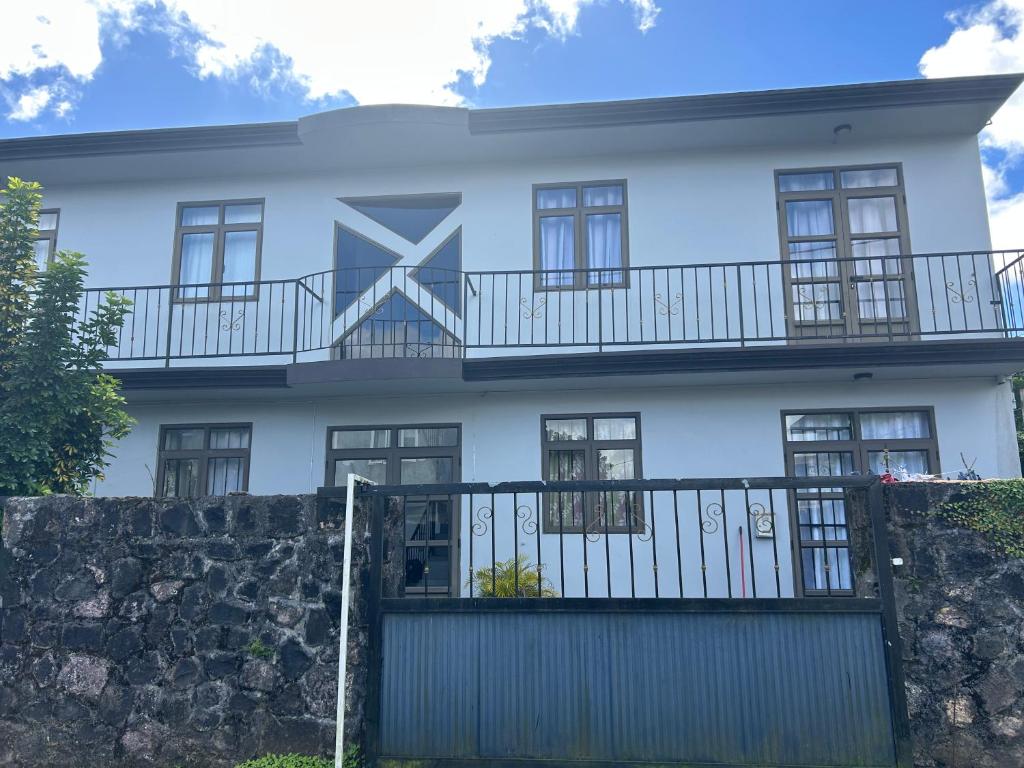a white house with a fence in front of it at The cozy nest in Curepipe