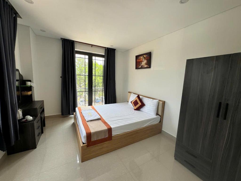 a bedroom with a bed and a large window at Luxury Hotel in Tây Ninh