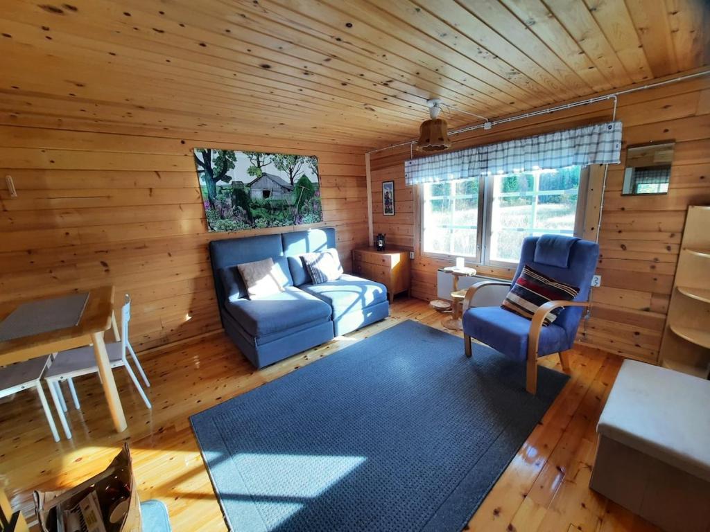 a living room with a blue couch and a table at Mökki Katjukka, Ruka in Kuusamo
