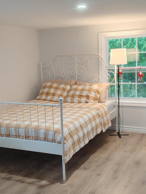 a bedroom with a bed and a lamp and a window at Bright Ensuite Room with 2 Queen Beds-3A in Halifax